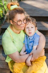 A mother gently hugs a disabled child. Infantile cerebral palsy. Enabling. Disability. A family...