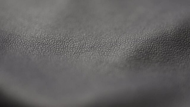 Slow motion handheld shot of soft gray brown leather closeup