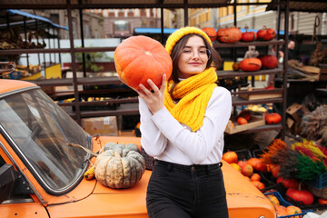 Young pretty woman holding orange halloween pumpkin. 