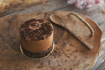 Truffle cake with chocolate mousse and cocoa sponge served on a wooden platter.