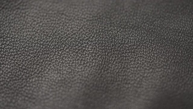 Slow motion handheld shot of soft gray brown leather closeup