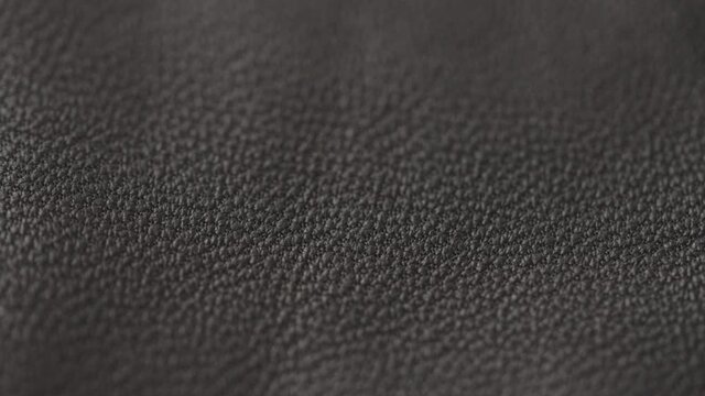 Slow motion handheld shot of soft gray brown leather closeup