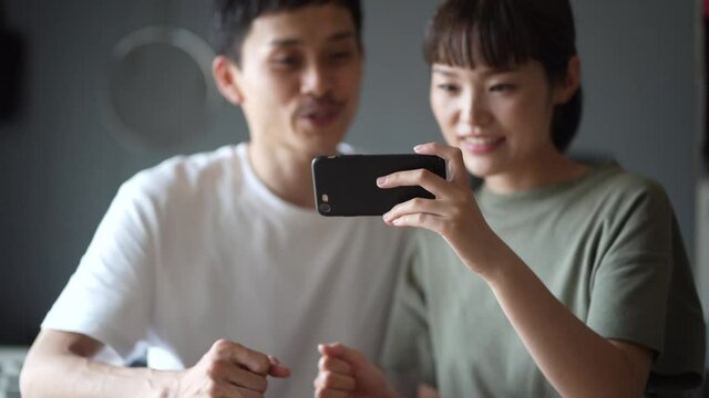 スマートフォンでスポーツ観戦するカップル