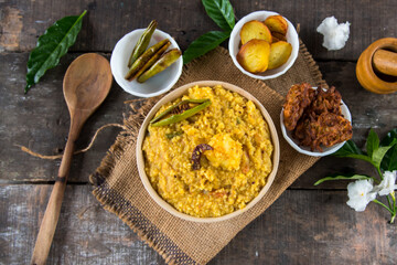 Dal khichadi or khichdi a delicious Indian recipe made of yellow dal or lentils and rice . Selective focus. It is generally accompanied with fried vegetables. - obrazy, fototapety, plakaty