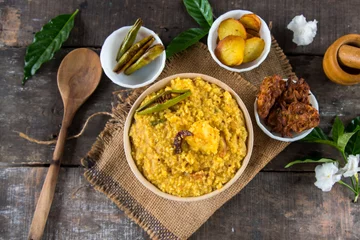 Fototapeten Dal khichadi or khichdi a delicious Indian recipe made of yellow dal or lentils and rice . Selective focus. It is generally accompanied with fried vegetables. © Debashis