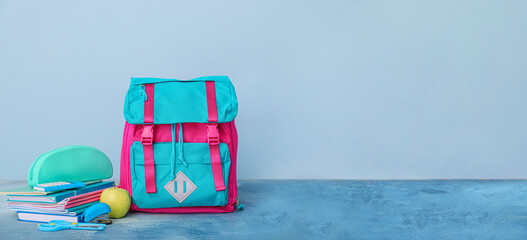 School backpack and stationery on color background with space for text
