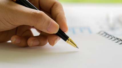 hand holding a pen to take notes on the account in the house