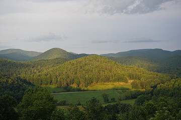 Obraz premium Beautiful mountain scenery with the sun highlighting the mountain in the foreground.