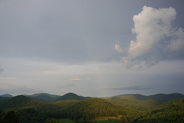 A picturesque view of the mountains as the sun highlights the mountain in the background.