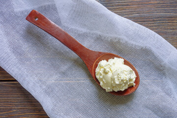 Balkan cuisine. Wooden spoon with kaymak - local soft white cheese.  Montenegro. Dark rustic table,...