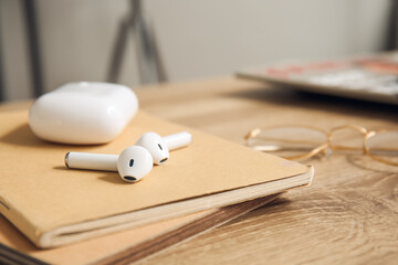 Earphones with notebooks on table in room, closeup