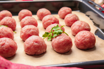 Baking tray with raw cutlets made of fresh forcemeat, closeup