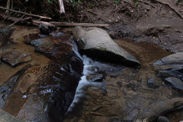 Water flows through a creek, long exposure.