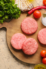 Wooden with raw cutlets made of fresh forcemeat on color background