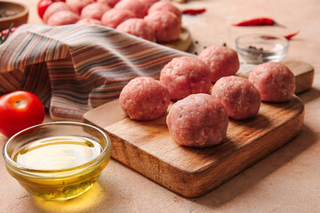 Wooden board with raw cutlets made of fresh forcemeat on light background