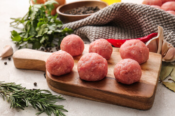 Wooden board with raw cutlets made of fresh forcemeat on table