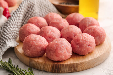 Wooden board with raw cutlets made of fresh forcemeat on table, closeup