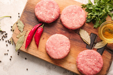 Composition with raw cutlets made of fresh forcemeat on light background