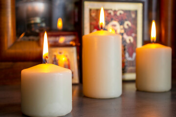 Fototapeta na wymiar Burning warm candles close-up on a table