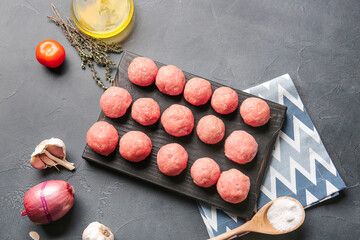 Composition with raw cutlets made of fresh forcemeat on dark background
