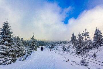 Fototapeta na wymiar Hikers people in snowed in landscape Brocken mountains Harz Germany.
