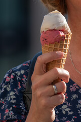 women holding a cornet of vanilla and strawberry Ice cream