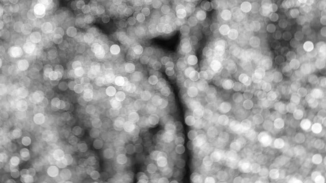 Close-up view 4k black and white stock video footage of smooth soft sparkling texture of elegant holiday glittering clothes or fabric. Shiny holiday silver abstract background