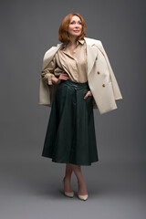 full length portrait of a fashionable aged woman isolated on grey