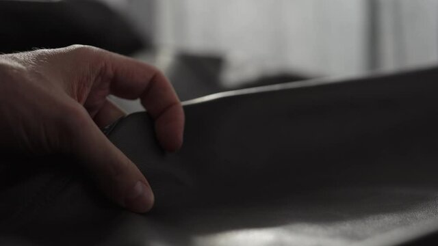 Slow motion shot man touching fine leather closeup