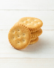 Rounded Cracker cookies on white wooden table background.