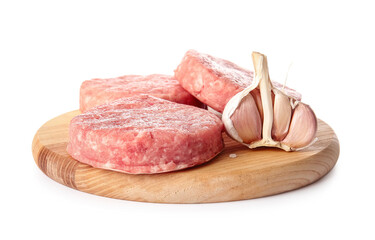 Wooden board with raw cutlets made of fresh forcemeat and garlic on white background