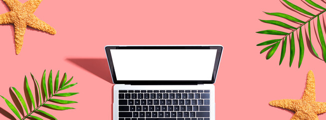 Laptop computer with summer palm plants and starfish