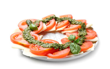 Plate with tasty caprese salad and pesto sauce on white background