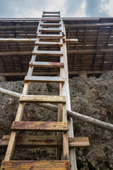 Old wooden ladder. Narrow ladder with steps to the sky. Climbing concept. Wooden stairway. Outdoor architecture concept. Opportunity illustration. Steps to success. Climb to the goal.