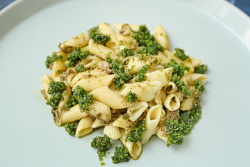 Plate with tasty pasta and sauce pesto, closeup