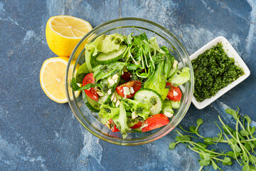 Bowl with tasty salad and pesto sauce on color background