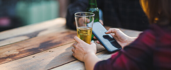 Cropped shot of people holding beer glasses celebrating in the summer camping party outdoor. Friends clinking bottle of beer during camping outdoor