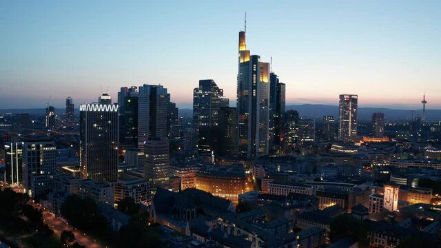 Frankfurt am Main Skyline and skyscrapers city lights cinematic panorama drone aerial fly away shot sunset evening
