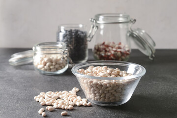 Bowl with raw beans on dark background