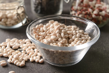 Bowl with raw beans on dark background
