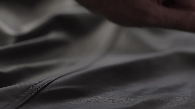Slow motion shot man touching fine leather closeup