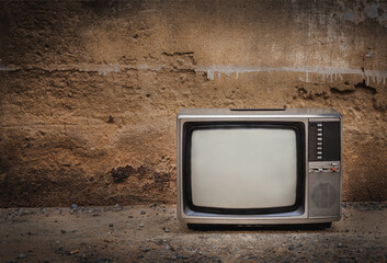 An old television in vintage brick wall background