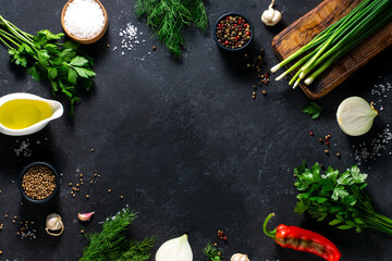 Fresh herbs, spices, peppers, dill, parsley on a black background. Place for text, culinary concept. Background for menu, recipe.
