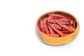 Dried pepper chillies in wooden bowl on white background.