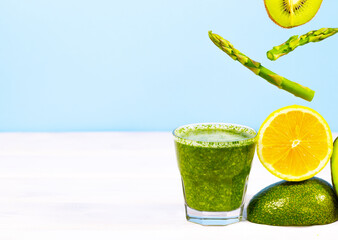 Blended Green smoothie with avocado, kiwi, asparagus and lemon on blue background. Healthy Eating. Diet Food. Copy Space