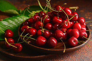 Plate with sweet cherries on grunge background