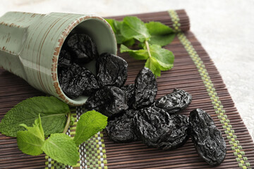 Cup with tasty prunes on light background, closeup