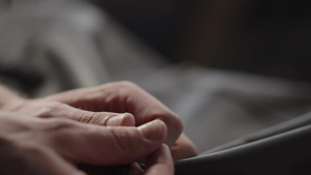 Slow motion shot man touching fine leather closeup
