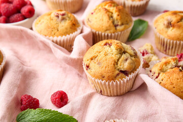 Tasty raspberry muffins on fabric background, closeup
