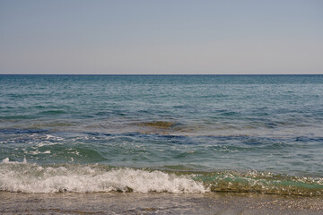 Waves with foam on Aegean sea coast in Crete Greece.